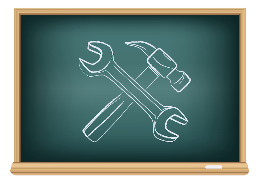 Chalkboard featuring a drawing in chalk of a wrench and hammer, suggesting a metaphor for tools used in school recruitment